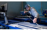 An image showing a Fujikura technician rolling graphite shafts