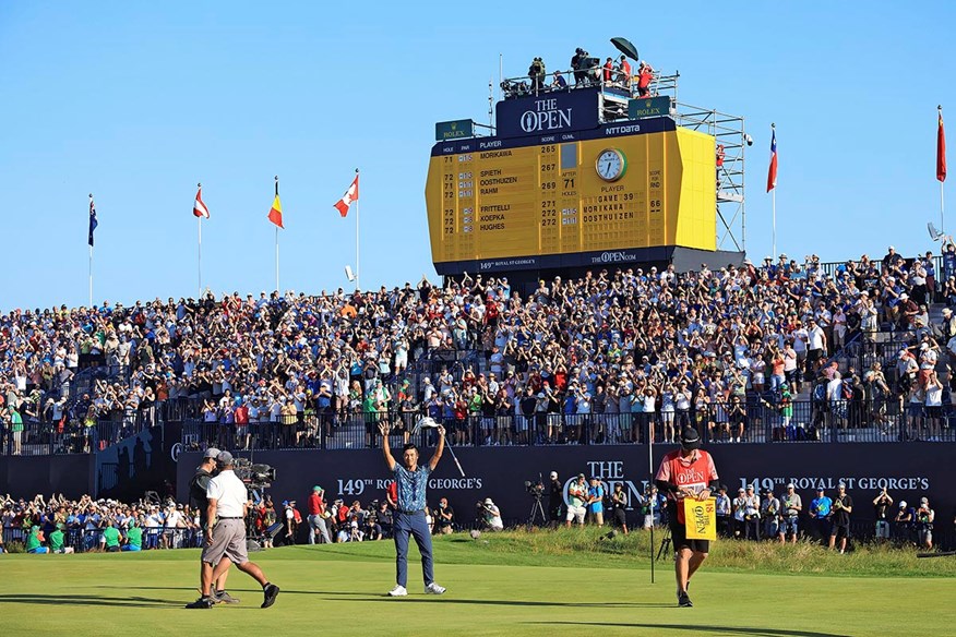 Collin Morikawa celebrates in front of the famous leadboard after his victory at Royal St George's.