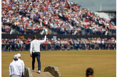 Tiger Woods doffs his cap to the crowd as he crosses the Swilken Bridge during his walk down the 18th hole at the end of his second round at the 150th Open Championship.