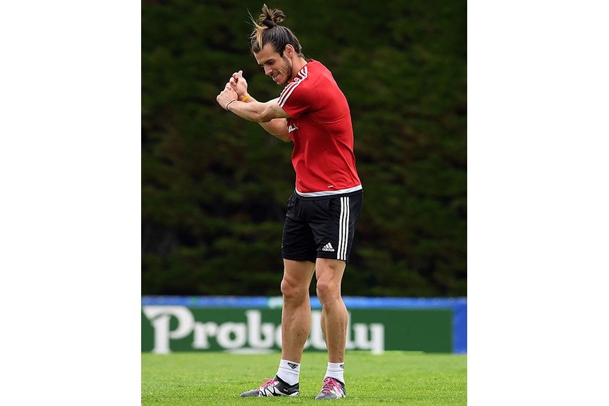 Gareth Bale checks his golf technique during Wales training.