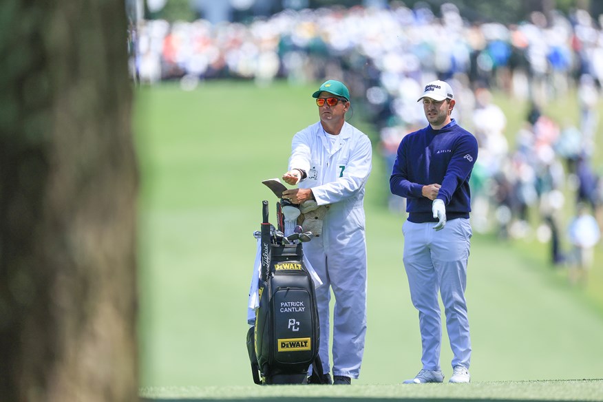 Patrick Cantlay consults with his caddie during the final round of the 2023 Masters.