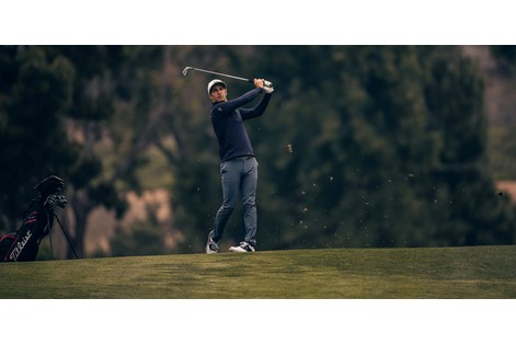 A golfer hitting the Titleist T100 2023 iron