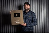 Rick Shiels poses with the golf YouTube plaque he received for reaching one million subscribers to his channel.