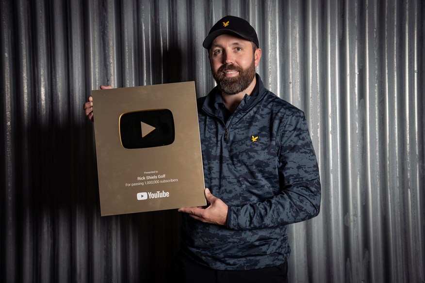 Rick Shiels poses with the golf YouTube plaque he received for reaching one million subscribers to his channel.