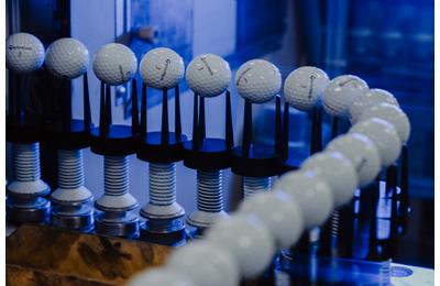 Golf balls on the paint line inside the TaylorMade golf ball plant