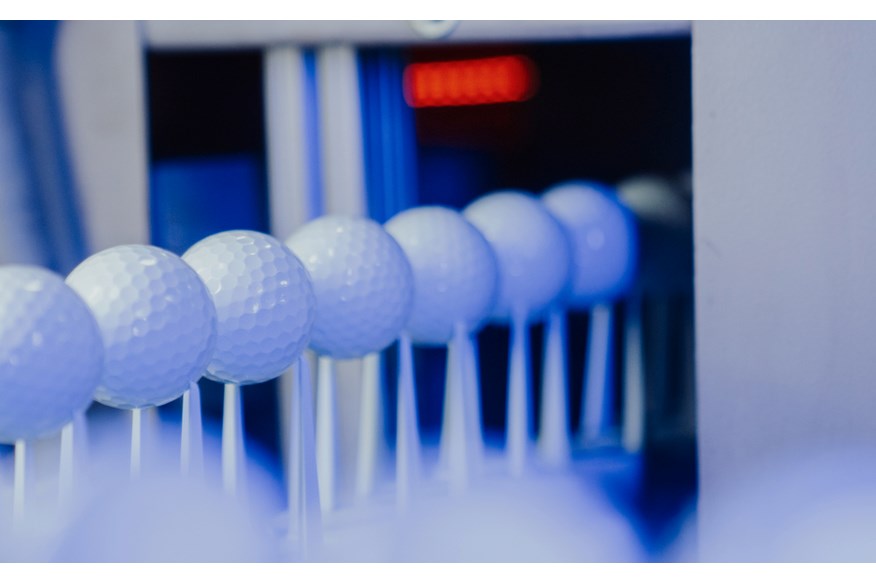 Golf balls on the paint line inside the TaylorMade golf ball plant 