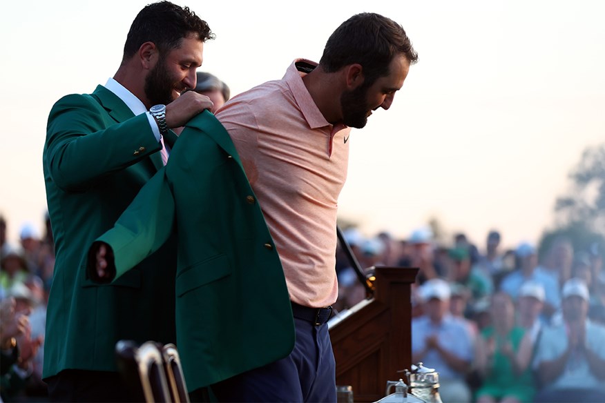 Jon Rahm putting the green jacket on Scottie Scheffler