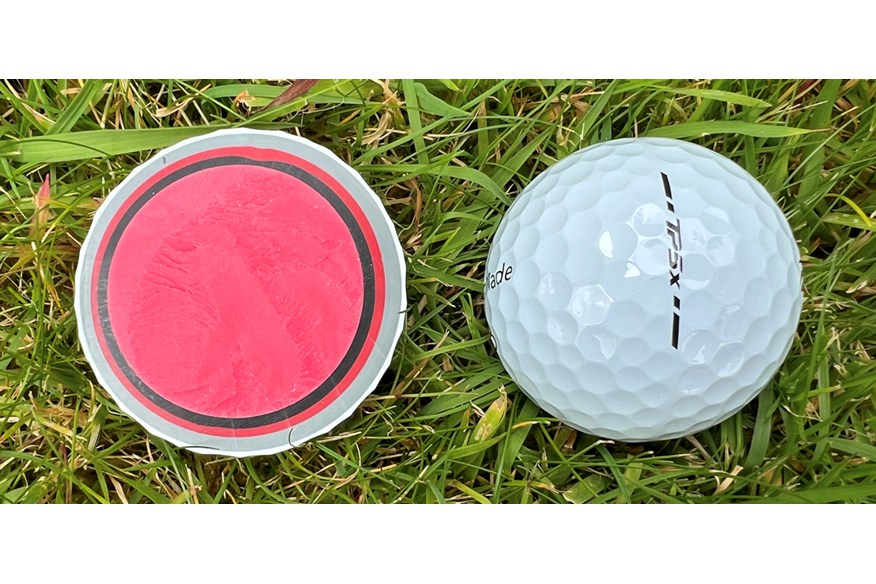 A TaylorMade TP5x golf ball cut in half to show the layers inside