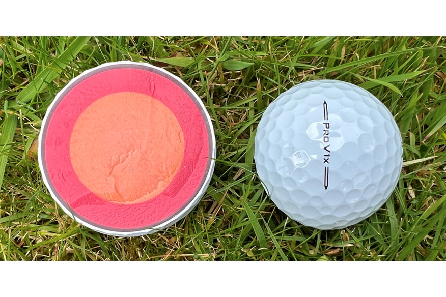 A Titleist Pro V1x golf ball cut in half to show the layers inside