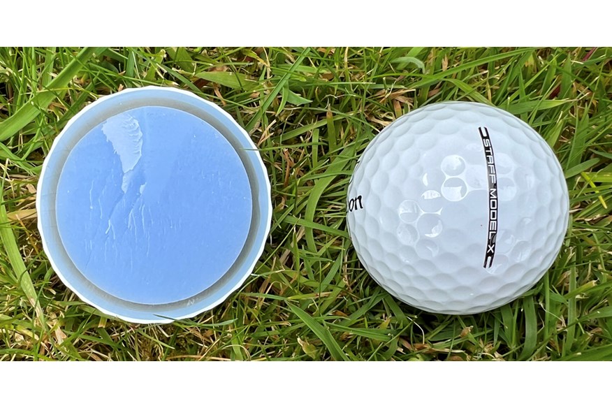 A Wilson Staff Model X golf ball cut in half to show the layers inside