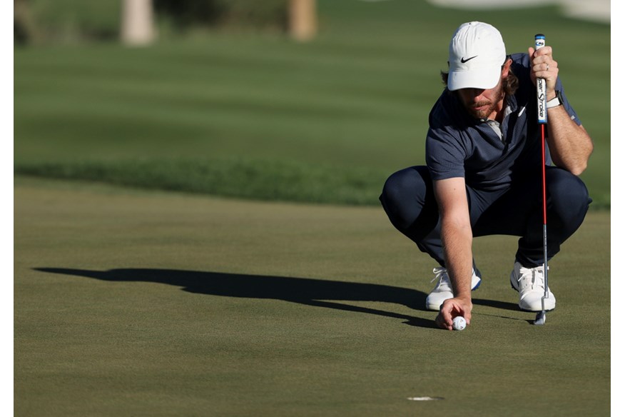 Tommy Fleetwood lining up a TaylorMade TP5x Pix golf ball on a green.