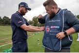 Jess helps put my caddie bib on for the round ahead