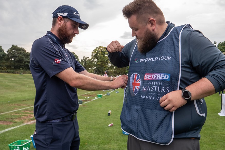 Jess helps put my caddie bib on for the round ahead