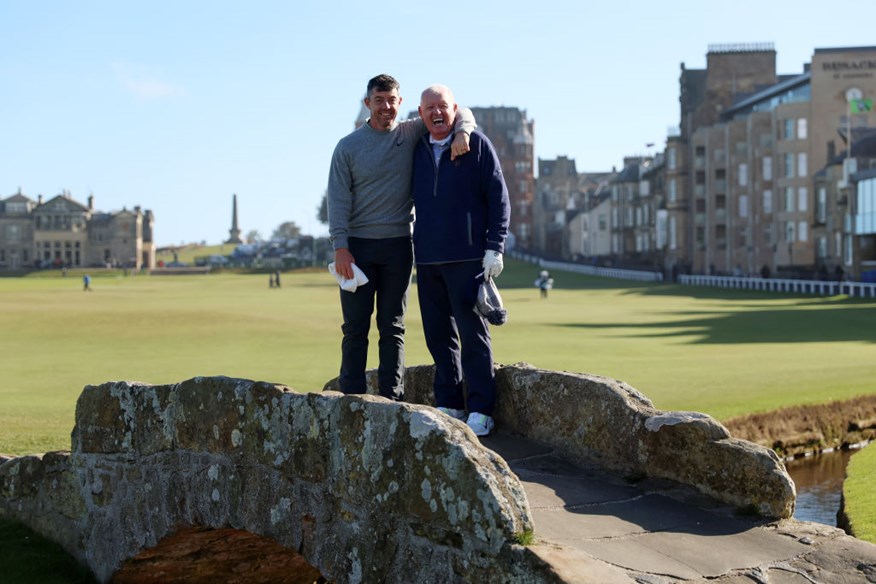 Rory McIlroy of Northern Ireland smiles alongside his father, Gerry McIlroy on the Swilcan Bridge during a practice round prior to the Alfred Dunhill Links Championship 2024 