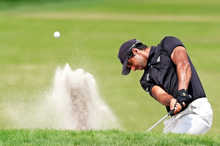 Aaron Rai wears one glove when hitting a bunker shot.