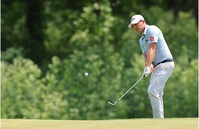 Matt FItzpatrick chips cross-handed.