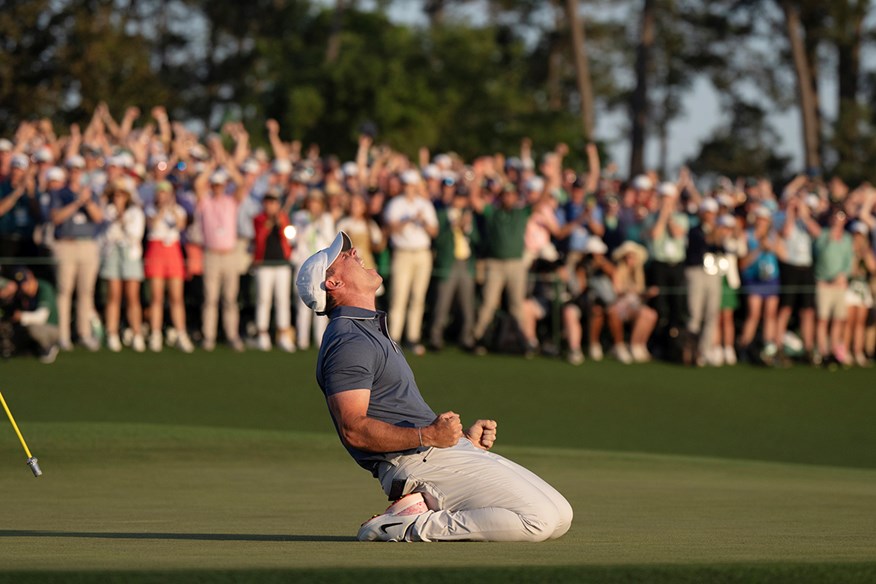 Rory McIlroy sinks to his knees and screams in delight on the 18th green at Augusta after winning The Masters in 2025.