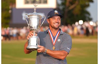 Bryson DeChambeau shows off the US Open trophy and gold medal.