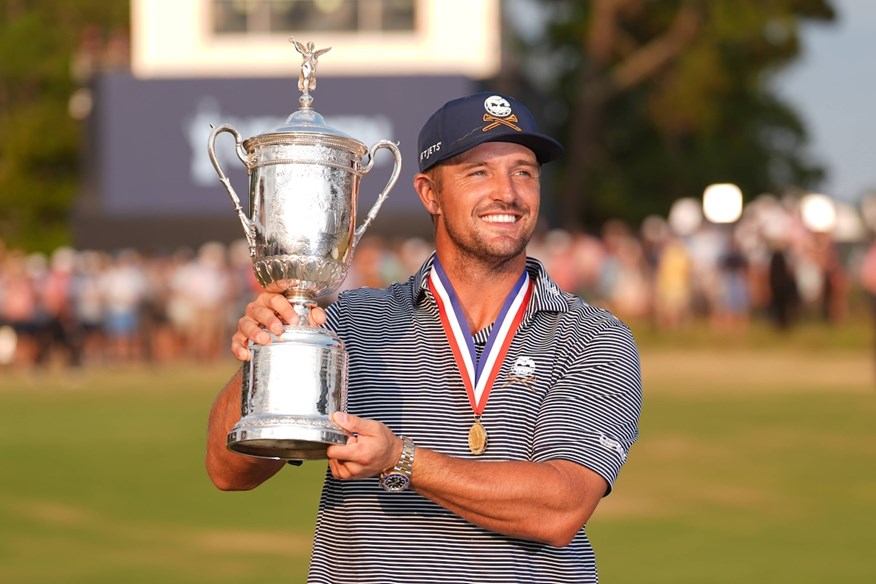 Bryson DeChambeau shows off the US Open trophy and gold medal.
