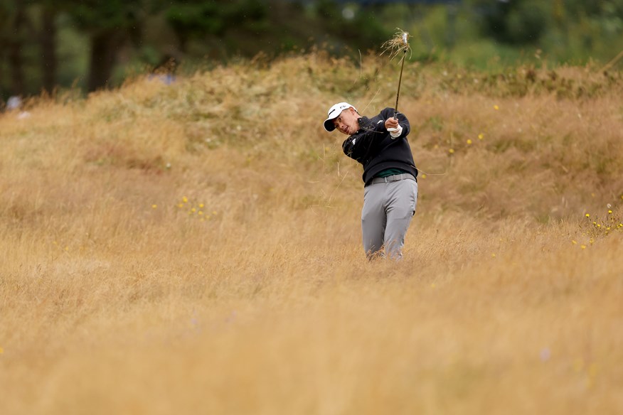 Collin Morikawa plays a shot from the rough