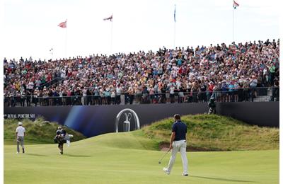 The crowd are on their feet as Scottie Scheffler makes the iconic walk up the 72nd hole at the Royal Portrush.