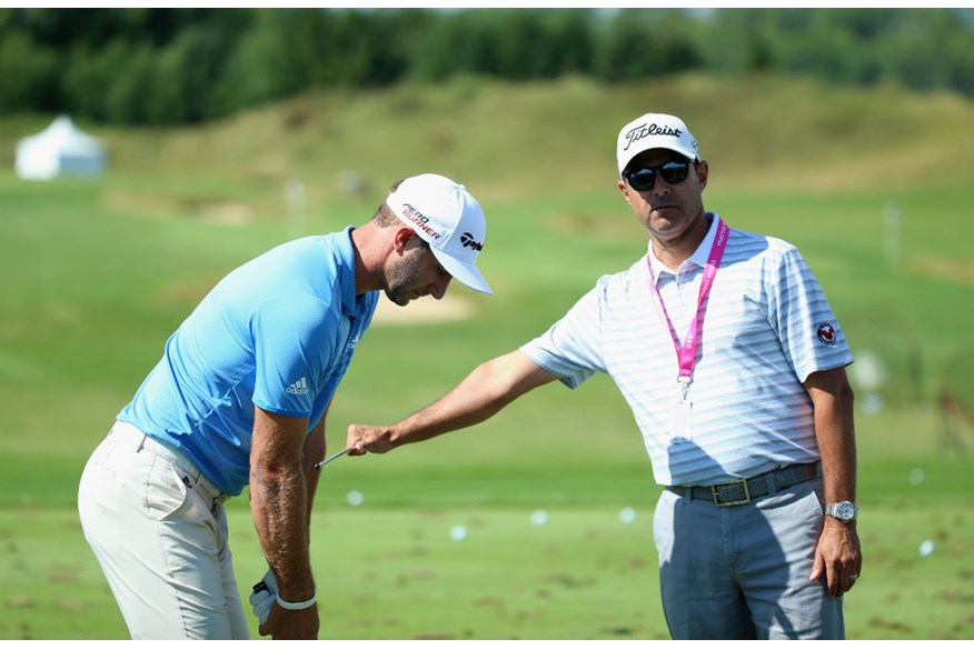 Dustin Johnson gets a few pointers from his coach