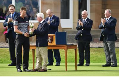 Henrik Stenson of Sweden is presented with the Claret Jug on the the 18th green in front of Todd Hamilton.