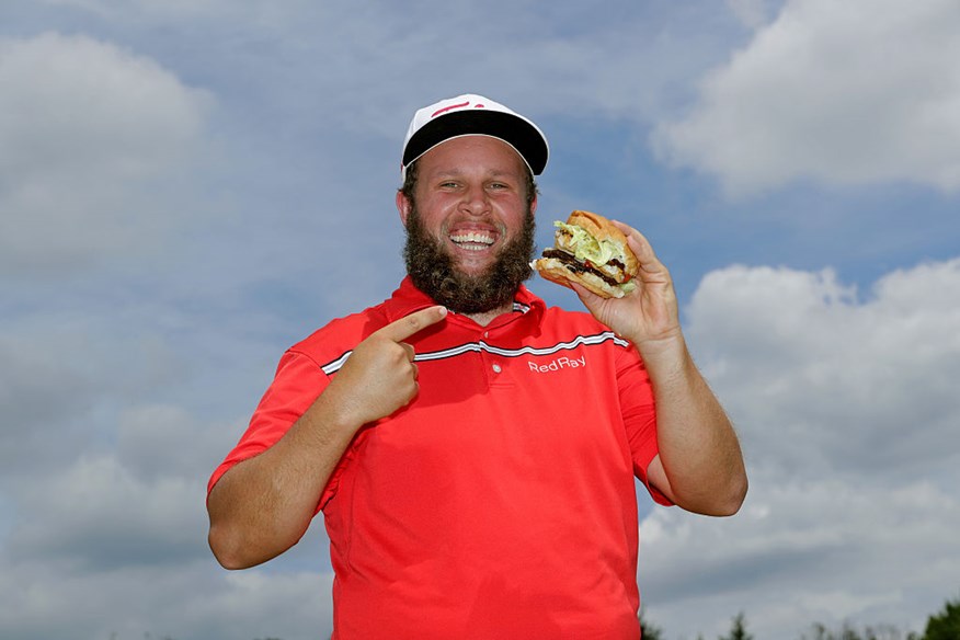  Andrew Johnston of England poses for a portrait with a hamburger after the third round of the World Golf Championships