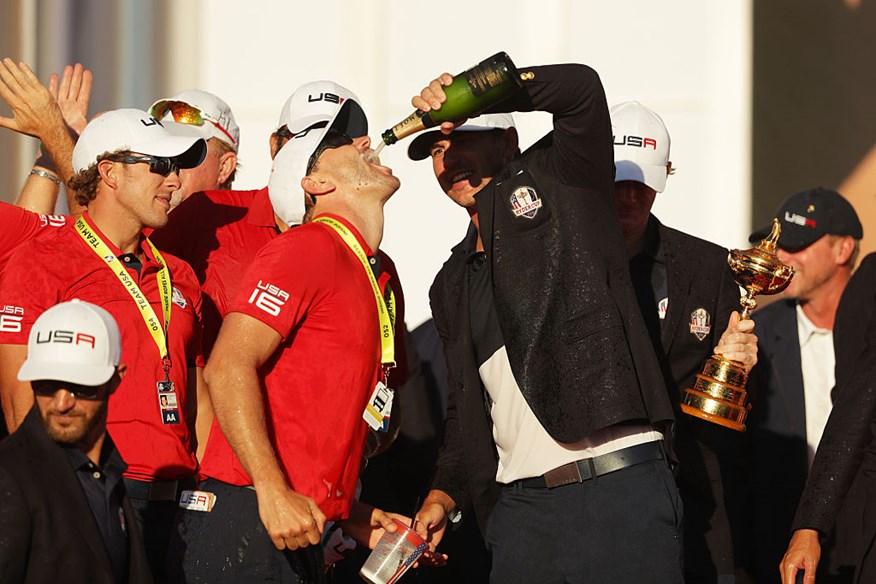 Brooks Koepka of the United States celebrates with a caddie during the closing ceremony