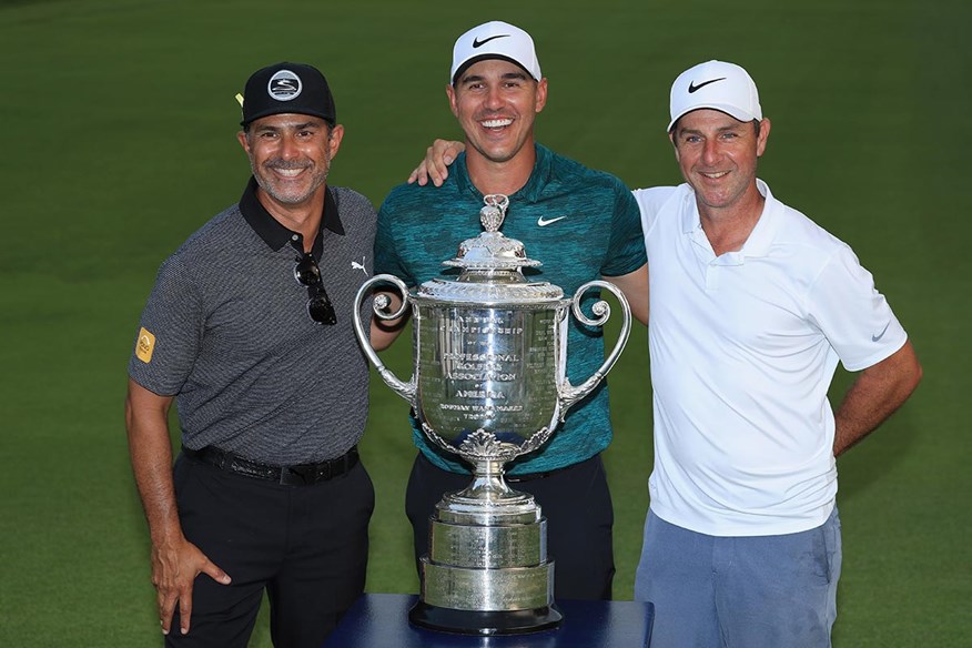 Brooks Koepka celebrates his 2018 US PGA win with coach Claude Harmon III and caddie Ricky Elliott.