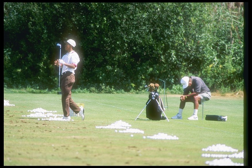 Tiger practises alongside father Earl.