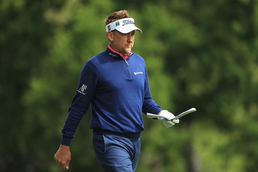 Ian Poulter consults his yardage book.