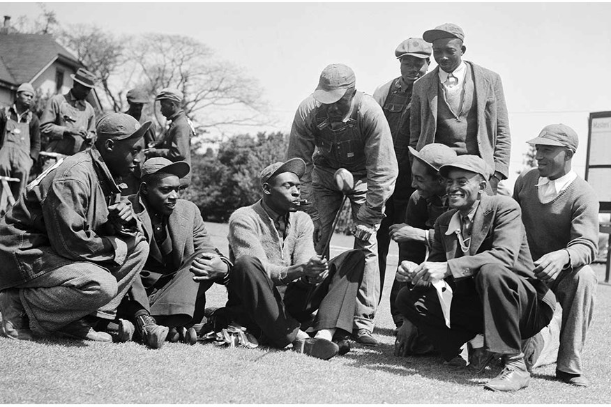 Sarazen’s caddie ‘Stovepipe’ shows other caddies the club which hit ‘the shot heard around the world’; an albatross on the 15th in 1935.