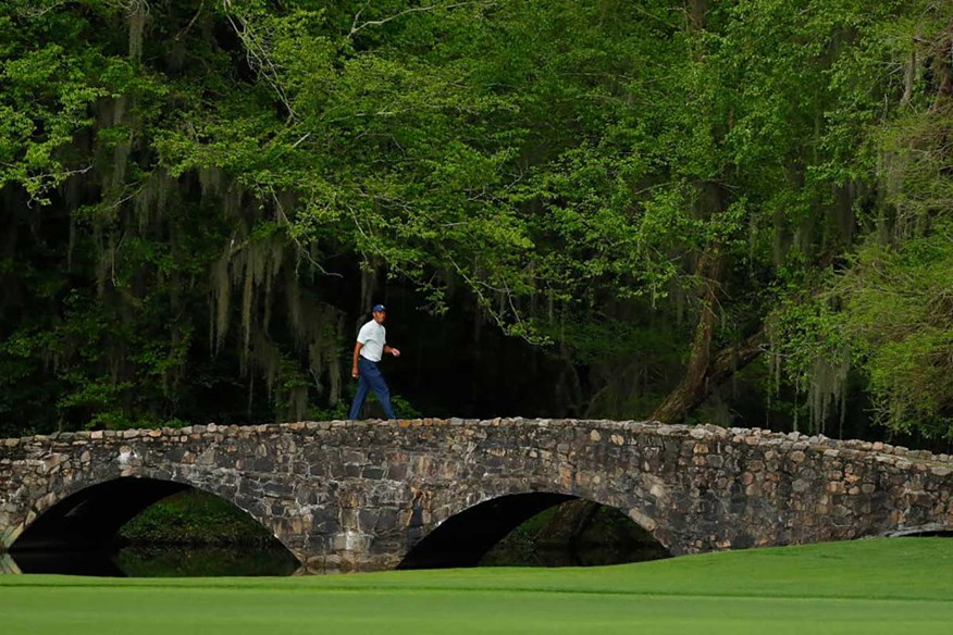 Tiger Woods walks across Nelson bridge at Augusta National Golf Club.